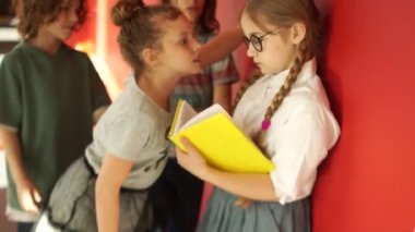 Okulda gençler arasında fiziksel istismar. Bir grup öğrenci yalnız bir kızı aşağılayıp, gözlüklerini yırtmış. Kız kaçıyor