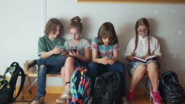 Öğrenciler ve gadget 'lar. Üç ergen telefonları hakkında tutkulu. Onların yanında otururken onur öğrenci kız bir kitap okur