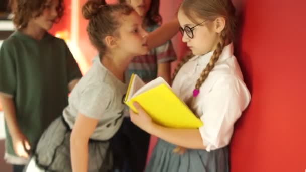 Abuso físico entre adolescentes na escola. Um grupo de estudantes insulta uma rapariga solitária, arranca-lhe os óculos. Menina foge — Vídeo de Stock