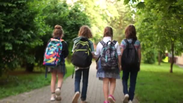 Adolescents joyeux sur le chemin de la sortie de l'école. Début des gadgets d'été, retour à l'école. Amitié scolaire — Video