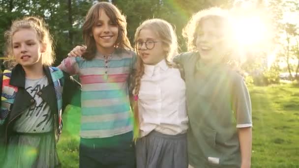 Nauwe portret van gelukkige schoolkinderen op de achtergrond van de ondergaande zon. Vier klasgenoten. Terug naar school — Stockvideo