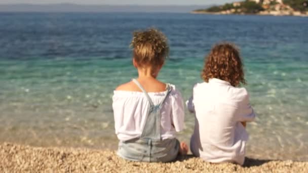 小さな女の子と男の子の日没で手を繋いでいるの背面します。愛、友情の概念 — ストック動画