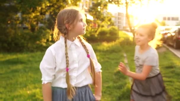 Buiten portret. Tiener vriendinnen knuffelen en lachen op een achtergrond van zonlicht, gelukkige kindertijd, schoolvakanties — Stockvideo