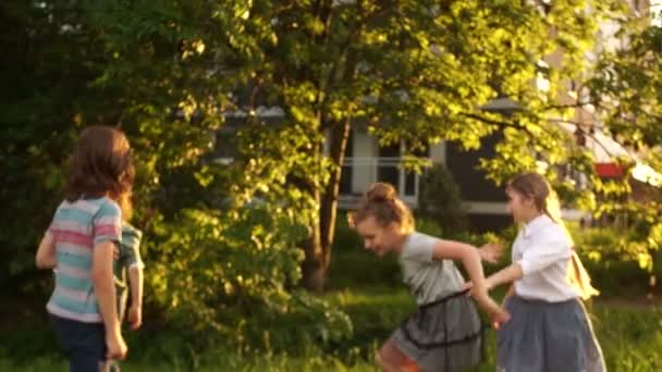 Un groupe d'enfants jouant dans un parc municipal. Eblouissement du soleil couchant, concept d'enfance heureuse, jeux pour enfants — Video