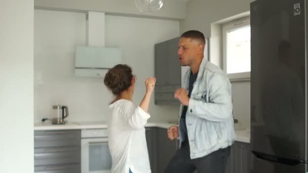 Cool young Caucasian pair having fun in their new apartment and rejoicing in slowmotion. Concpet of happines and joy — Stock Video