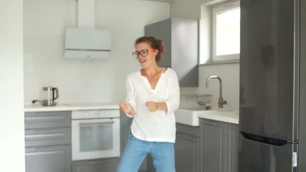 Portrait of a beautiful young woman dancing in her new kitchen after the renovation is completed. Real estate repair concept — Stock Video