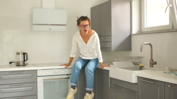 Heureuse épouse se réjouit d'acheter une nouvelle cuisine. Immobilier et réparations. Jeune femme dansant à l'intérieur d'un nouvel appartement — Video