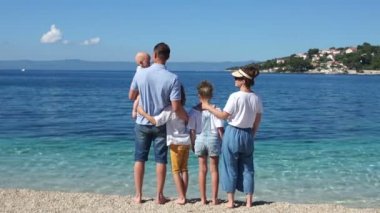 Akdeniz 'in kıyılarında üç çocuk olan aile. Hırvatistan 'da tatiller, Aile seyahat konsepti