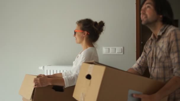 Il ragazzo e la ragazza vengono nel loro appartamento per la prima volta dopo la riparazione. Trasferimento, acquisto di beni immobili — Video Stock
