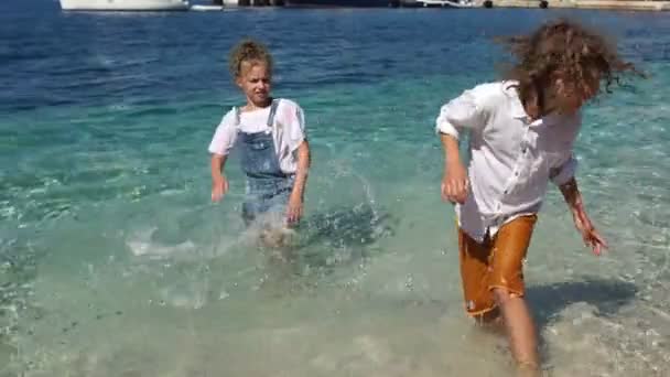 Glückliche Kinder freuen sich und spielen im Meerwasser. Kinder sind nass und glücklich, Ferien mit Kindern, Schulferien