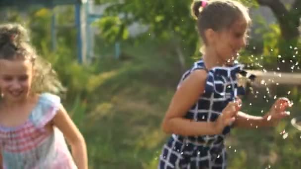 Los niños juegan bajo la lluvia de verano. Niño jugando al aire libre en el día lluvioso. Niña cogiendo gotas de lluvia bajo la ducha pesada. Niños al aire libre por cualquier clima . — Vídeo de stock