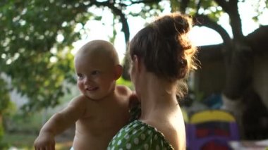 Tatilde köyde bahçede anne ve bir yaşındaki bebek yakın portre. Yaz tatili, anneler günü