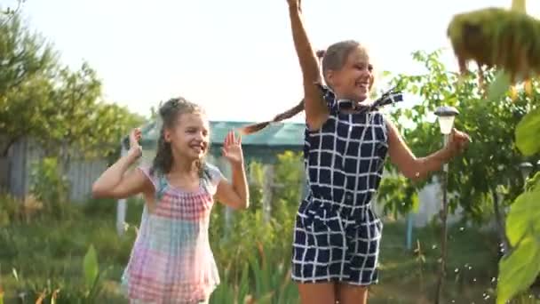 십대 소녀는 물 줄기 아래 태양에서 점프하고 있습니다. 해피 홀리데이 컨셉, 여름 방학 — 비디오