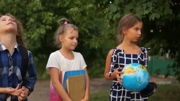 Los estudiantes van a la escuela en el pueblo en una carretera rural. Estudiar en Europa del Este, volver a la escuela, educación — Vídeos de Stock