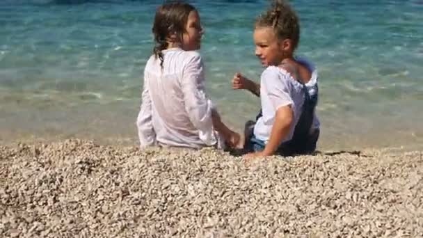 Iskolás a tengerparton. Gyermek megfordul, és mutat egy hüvelykujj gesztus az osztályban. Nyári szünidő, boldog gyerekek — Stock videók