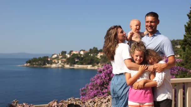 Terasz tenger mellett, szülők gyerekekkel, Nyaralás gyerekekkel, Nyári szünidő. Egy mediterrán üdülőhely egy három gyermekes család pihenéssel — Stock videók