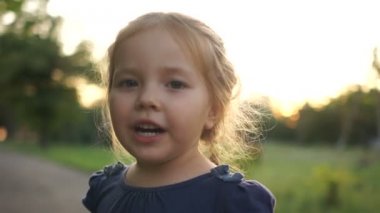 Batan güneşe karşı bir yaz köyünde mutlu küçük kız. Yaz tatilleri, sağlıklı yaşam tarzı