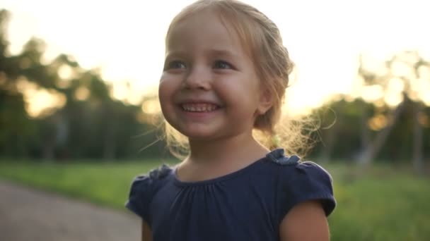 Menina bonito no prado na noite do dia de verão. Retrato fechado — Vídeo de Stock