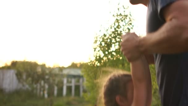 Zorgzame jonge vader in het park maakt zijn kleine dochter haar bij de hand. Gelukkige kindertijd, vaders dag, vader en dochter — Stockvideo