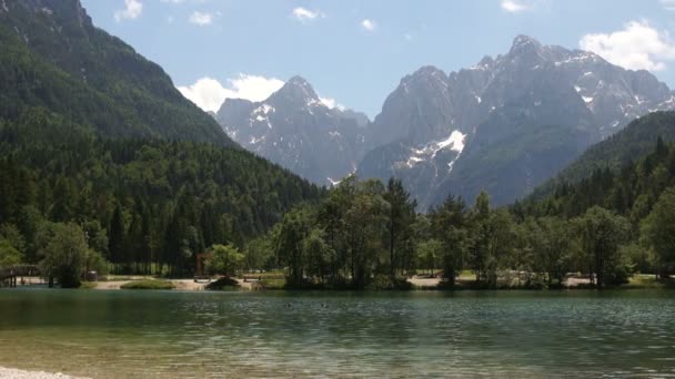 Hırvatistan'da bir dağ gölügüzel görünümü. Mavi-yeşil şeffaf su ve dalgalar yüksek karla kaplı zirvelerin arka plan karşı. Seyahat konsepti — Stok video