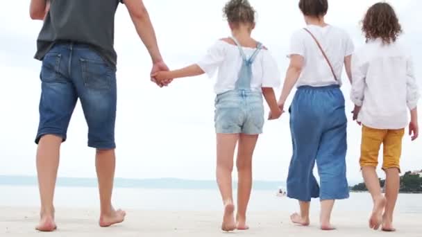 Счастливые родители с детьми, отдыхающими на песчаном пляже. Счастливого семейного отдыха. Белый песок на экзотическом пляже. Дружественная семья из пяти человек — стоковое видео