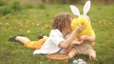 İki kardeş, bir genç ve bir bebek paskalya sepetiyle oynuyorlar. Paskalya Tavşanı Kostümü, Mutlu Paskalya Ailesi