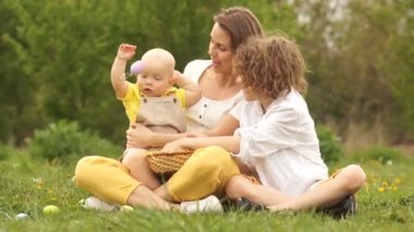 Mutlu bir aile parkta piknikte. Çocuk Paskalya tavşanı kostümü düşünüyor. Paskalya ailesi, iki erkek ve anne