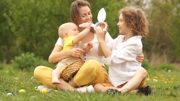 Мама и дети на пасхальном пикнике в парке. Happy Weekend, пасхальный костюм кролика — стоковое видео