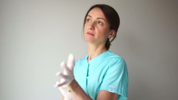 Όμορφη καυκάσιος γιατρός ή νοσοκόμα βάζοντας λευκό αποστειρωμένο γάντι. Διεθνής Ημέρα Νοσοκόμων — Αρχείο Βίντεο