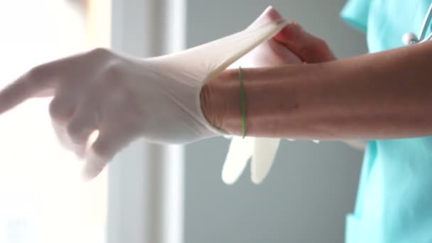 Dia internacional da enfermeira. Close-up de mãos femininas usando luvas estéreis em um consultório médico, manipulações médicas — Vídeo de Stock