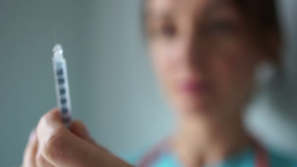 Närbild av en kvinnlig läkare som håller en spruta framför ansiktet. Diabetesbehandling, influensavaccin — Stockvideo
