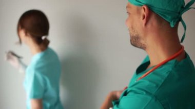 Doktor ve hemşire bir koğuşta görüşüyorlar. Tıbbi personel gülüyor, tıbbi espri yapıyor.