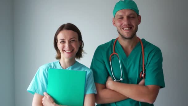 Portrait of smiling male and female doctors in medical gowns. Medical staff, medicine and healthcare — Stock Video