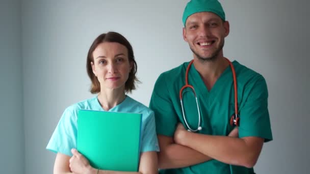 Медицинский персонал, медицина и здравоохранение. Портрет улыбающихся врачей мужского и женского пола в медицинских платьях — стоковое видео