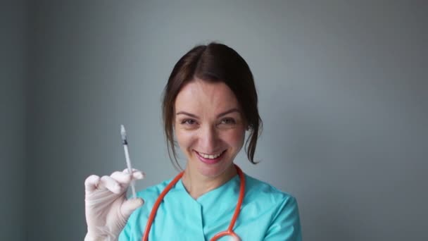 Verpleegster wenkt met een vinger in een steriele handschoen. Een vrouw houdt een spuit in haar rechterhand. Medische manipulaties — Stockvideo