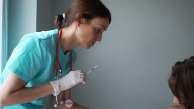Bağışıklık programı, grip aşısı. Doktor bebeğin annesinin kollarında oturmasını aşıladı. Ağlayan bebek, tıbbi manipülasyonlar, pediatri konsepti