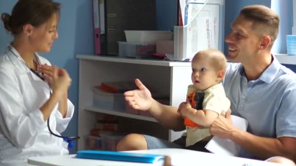 Avslutande av en tid som barnläkare. Unge far säger adjö till en kvinnlig läkare och lämnar med sin lille son — Stockvideo