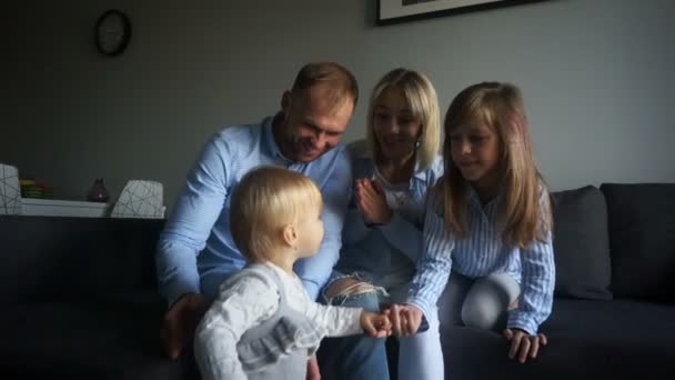Bebé de un año y sus padres y su hermana mayor se divierten en casa. Familia feliz en casa el fin de semana — Vídeos de Stock