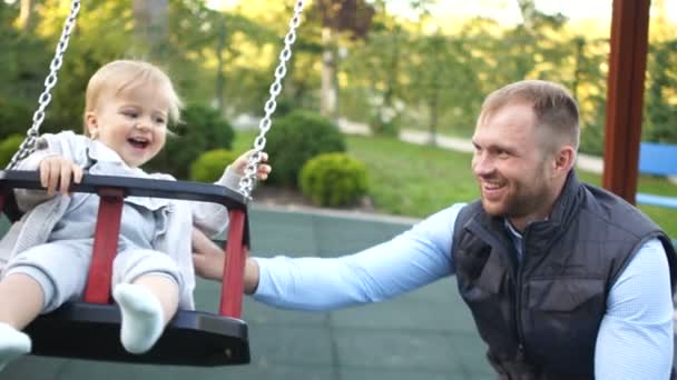 Zorgzame vader loopt met zijn dochter op de speelplaats. Vader en dochter op een wandeling. Vaderdag — Stockvideo