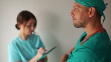Cerrah hasta için ilaç randevusu alır, hemşire talimatlarını yazar. Klinik sağlık personeli iş başında.