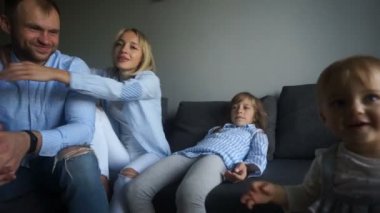 Mutlu genç ebeveynler iki kızlarıyla evde eğleniyor. Mutlu aile hafta sonu