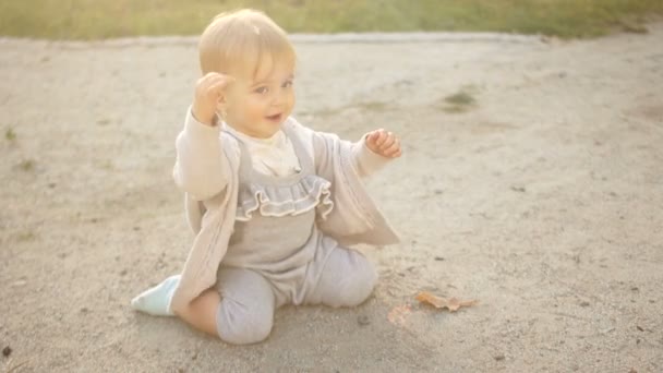 Criança alegre brincando na areia no playground. Passeio de verão, bebê de um ano, infância feliz — Vídeo de Stock