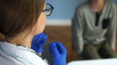 Çalışan doktorların pediyatristi. Kadın bir doktor fonendoskop takar ve hastaların nefes alışlarını dinlemeye hazırlanır. Arka görünüm, kapat
