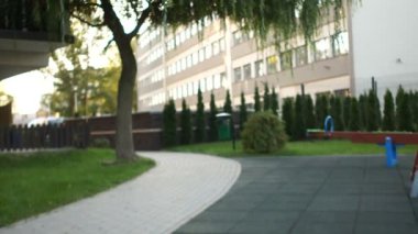 Genç, neşeli bir anne kızı bebek arabasında otururken çocuk parkında sallanıyor. Anneler Günü