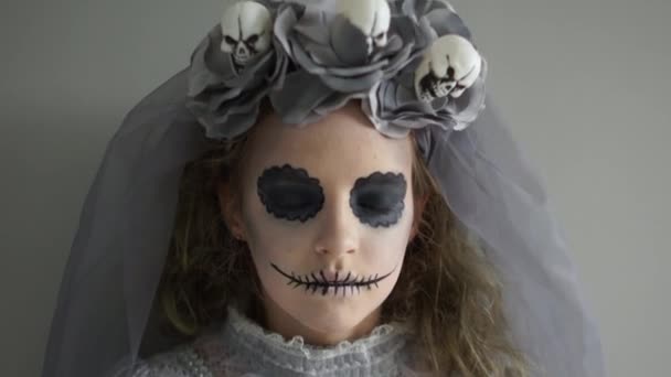 Portrait of a beautiful teenager girl in a gray suit and makeup of a dead bride. Halloween traditions. Veil with skulls — Stock Video