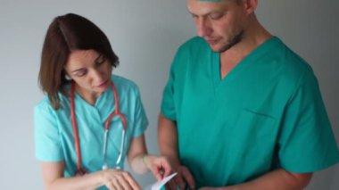 Uluslararası Doktorlar Günü. İç doktorlar hasta testlerinin sonuçlarını tartışıyor. Klinik sağlık personeli iş başında.