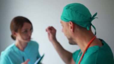İki doktor arasındaki duygusal anlaşmazlık. Bir erkek doktor ve bir bayan asistan teşhis ve tedaviyi tartışıyor. Tıbbi personel iş başında.