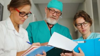Doktor cerrah ve iki tıp asistanı genç bayan. Klinik sağlık personeli iş başında. Yakın portre, tıp ve sağlık hizmeti kavramı