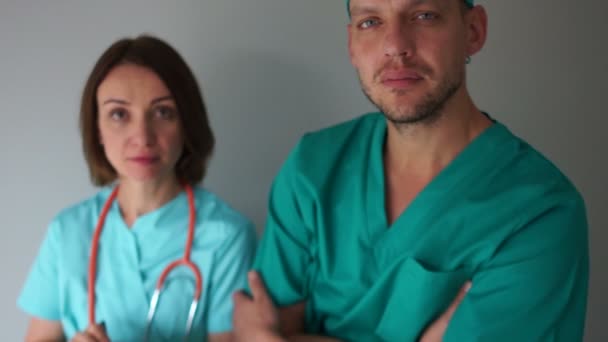 Uomo e donna in abito medico guardare seriamente nella fotocamera. Medicina e assistenza sanitaria, personale medico della clinica — Video Stock