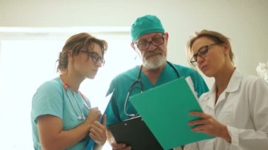 Acil bir hastanede pencereye bakan üç doktor, acil durumlar, acil ameliyatlar...